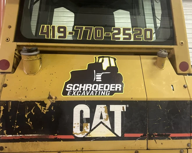 a view of the bulldozer with the company logo and telephone number